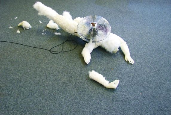 Künstler Jan Moritz Stahl - Ein beschädigter, weißer Mensch liegt auf dem Boden mit einem Kragen.