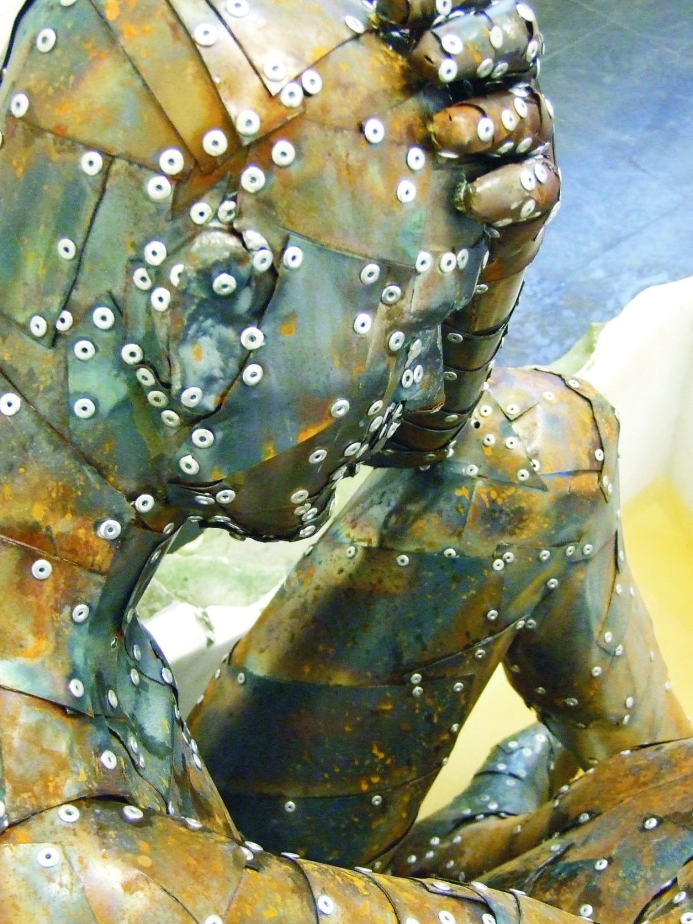 Don Quijte Künstler Jan Moritz Stahl - Eine skulpturale Darstellung eines nachdenklichen, sitzenden Menschen in Metalloptik.