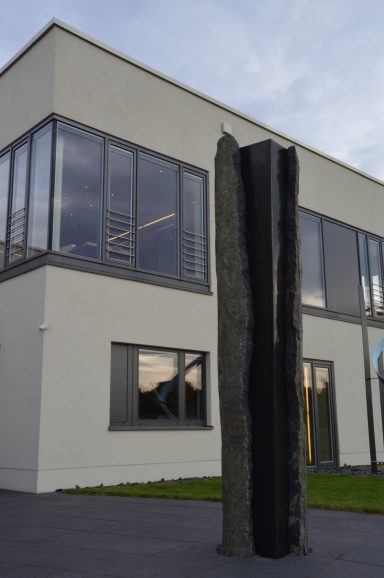 Künstler Jan Moritz Stahl - Skulptur mit schlanker, vertikaler Form vor einem modernen Gebäude.